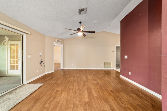 9001 SW 91st Cir, Ocala, FL 34481 - unfurnished living room featuring light wood-style flooring, a ceiling fan, lofted ceiling, and a textured ceiling