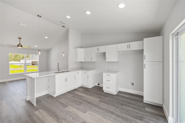 16697 SW 30 Avenue Rd, Ocala, FL 34473 - kitchen with a sink, white cabinets, a peninsula, a ceiling fan, and baseboards