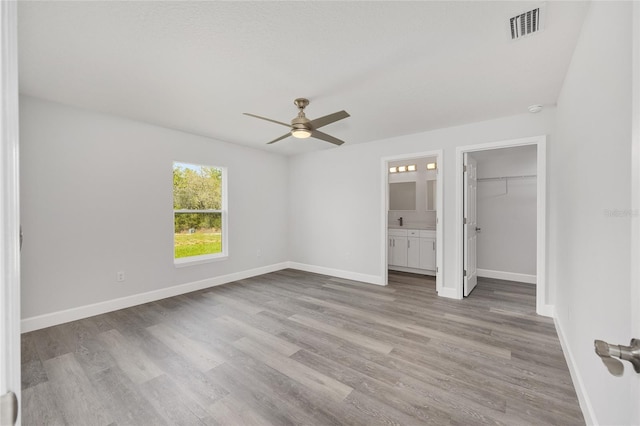 16697 SW 30 Avenue Rd, Ocala, FL 34473 - unfurnished bedroom with light wood-style flooring, baseboards, a spacious closet, and ensuite bath
