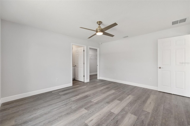 16697 SW 30 Avenue Rd, Ocala, FL 34473 - unfurnished bedroom with wood finished floors, baseboards, a walk in closet, a ceiling fan, and a closet