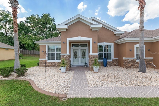 12804 SE 90th Court Rd, Summerfield, FL 34491 - view of front facade with stone siding, stucco siding, french doors, and roof with shingles