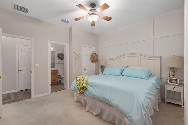 12804 SE 90th Court Rd, Summerfield, FL 34491 - bedroom featuring light carpet, connected bathroom, baseboards, and a ceiling fan