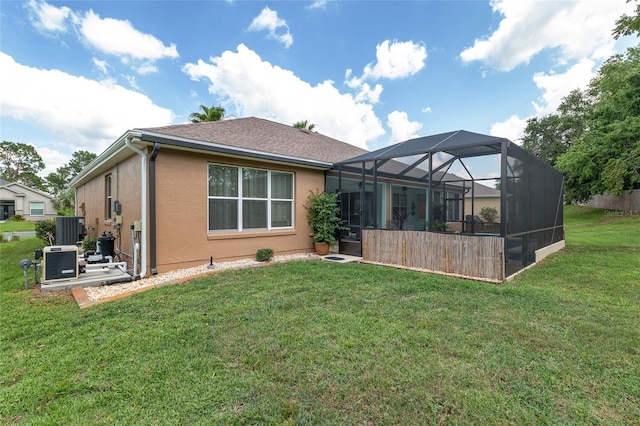 12804 SE 90th Court Rd, Summerfield, FL 34491 - back of house with stucco siding, a lawn, central AC unit, and a lanai