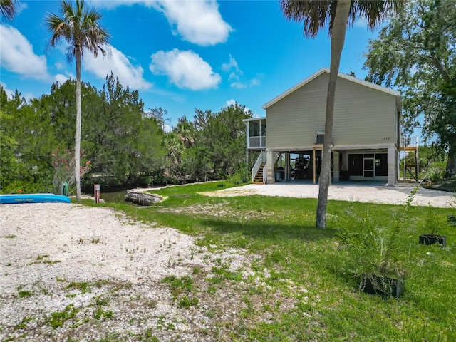 1575 S Wallace Pt Unit 23, Crystal River, FL 34429 - view of green lawn featuring a sunroom, a carport, and stairway