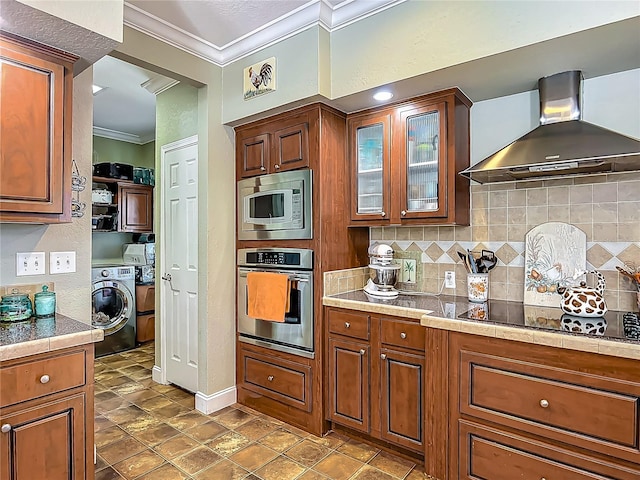 1575 S Wallace Pt Unit 23, Crystal River, FL 34429 - kitchen with stainless steel appliances, wall chimney exhaust hood, crown molding, decorative backsplash, and glass insert cabinets