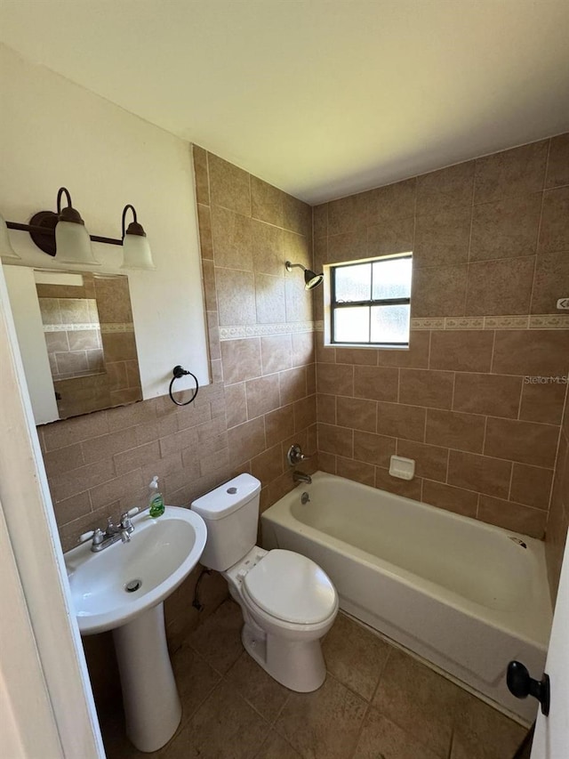 3740 NE 5th St, Ocala, FL 34470 - full bathroom featuring tile walls, toilet, washtub / shower combination, and tile patterned flooring