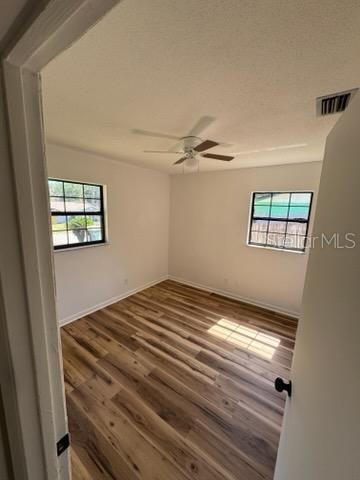 3740 NE 5th St, Ocala, FL 34470 - unfurnished room with plenty of natural light, ceiling fan, wood finished floors, and baseboards