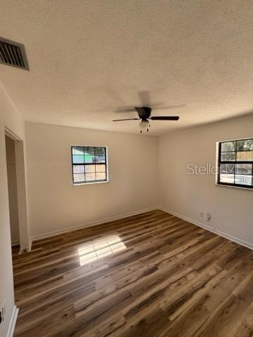 3740 NE 5th St, Ocala, FL 34470 - unfurnished room with dark wood-style floors, a ceiling fan, a textured ceiling, and baseboards
