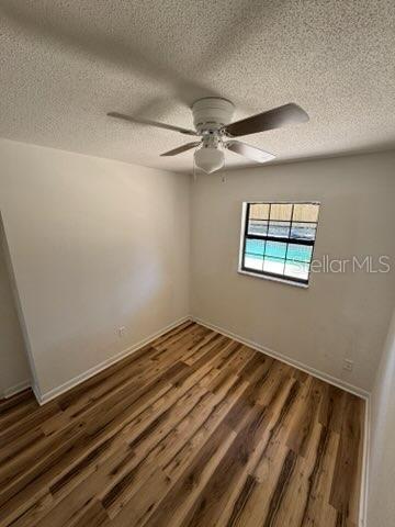 3740 NE 5th St, Ocala, FL 34470 - spare room featuring a textured ceiling, wood finished floors, ceiling fan, and baseboards