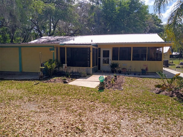 22736 SW 117th St, Dunnellon, FL 34431 - view of front of home with a sunroom, metal roof, a front yard, and a patio area