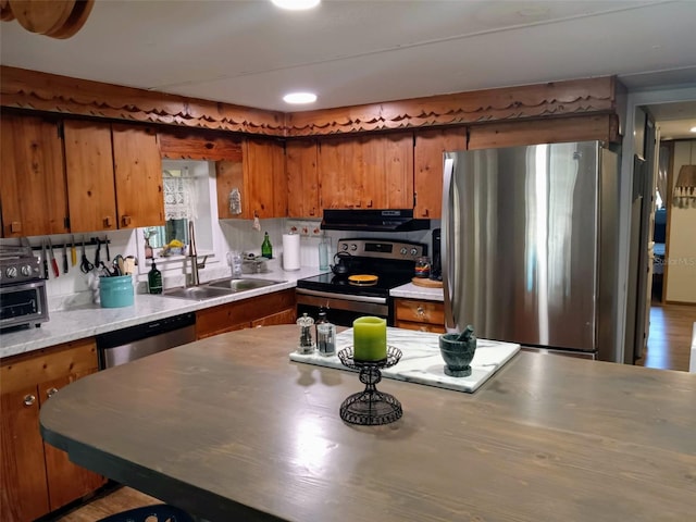 22736 SW 117th St, Dunnellon, FL 34431 - kitchen featuring appliances with stainless steel finishes, brown cabinets, under cabinet range hood, and a sink