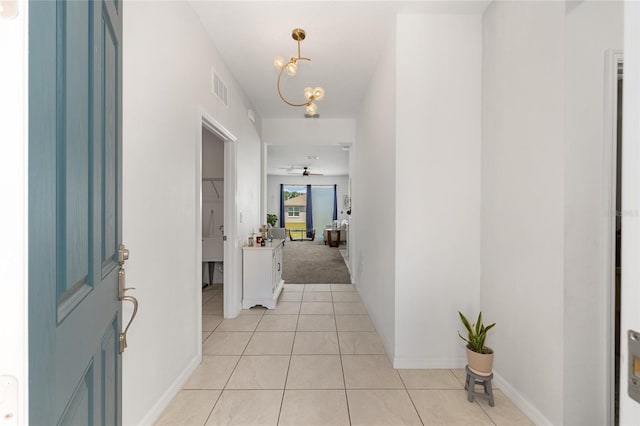 7571 SW 64th Street Rd, Ocala, FL 34474 - corridor featuring light tile patterned flooring, a chandelier, and baseboards
