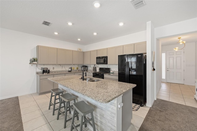 7571 SW 64th Street Rd, Ocala, FL 34474 - kitchen with black appliances, light tile patterned floors, an island with sink, a sink, and a kitchen breakfast bar