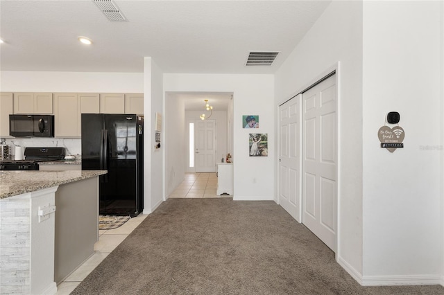 7571 SW 64th Street Rd, Ocala, FL 34474 - kitchen featuring black appliances, light tile patterned flooring, light stone countertops, light colored carpet, and baseboards