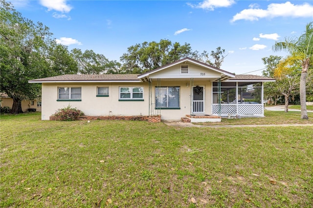 705 Washington Ave, Eustis, FL 32726 - view of front of house featuring a front lawn, stucco siding, and a sunroom