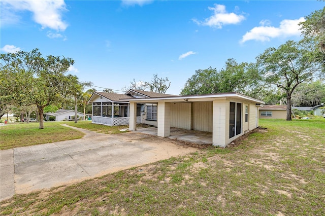 705 Washington Ave, Eustis, FL 32726 - view of front of property featuring a sunroom, a front lawn, driveway, and a carport