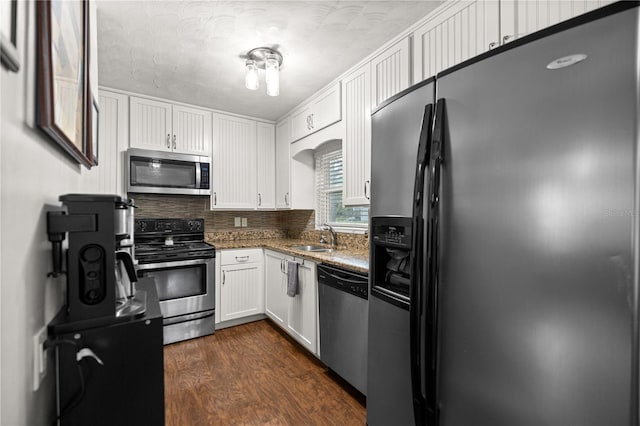 705 Washington Ave, Eustis, FL 32726 - kitchen with appliances with stainless steel finishes, a sink, white cabinets, dark stone countertops, and dark wood-style floors