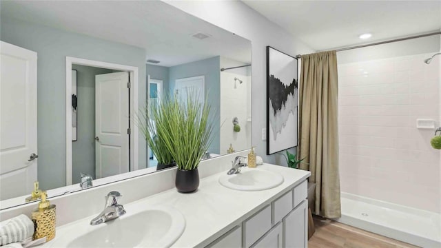 4937 SW 51st Rd, Gainesville, FL 32608 - full bath with tiled shower, double vanity, and wood finished floors