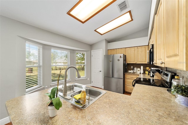 11 SE Fir Trail Trak, Ocala, FL 34472 - kitchen featuring appliances with stainless steel finishes, light brown cabinetry, a sink, lofted ceiling, and decorative backsplash