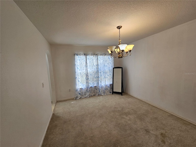 18 Fir Trail Dr, Ocala, FL 34472 - spare room featuring arched walkways, light colored carpet, a chandelier, baseboards, and a textured ceiling