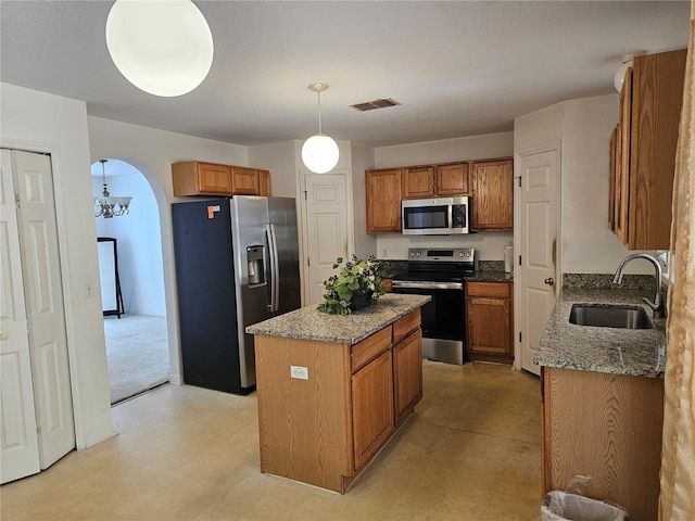 18 Fir Trail Dr, Ocala, FL 34472 - kitchen with appliances with stainless steel finishes, a sink, a center island, and brown cabinets