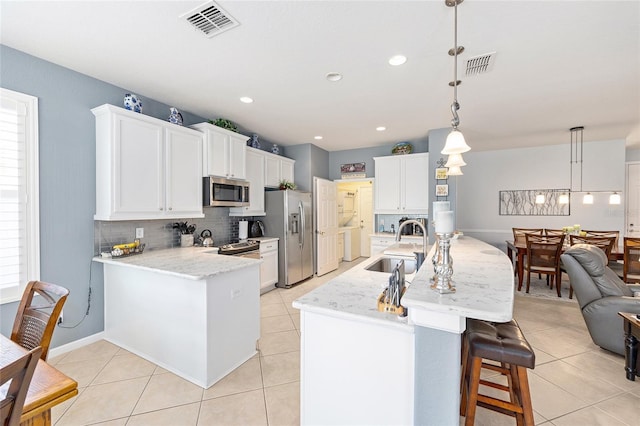 7333 SW 98th Ct, Ocala, FL 34481 - kitchen with stainless steel appliances, a sink, backsplash, a kitchen breakfast bar, and light tile patterned floors