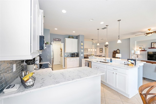 7333 SW 98th Ct, Ocala, FL 34481 - kitchen with a sink, open floor plan, decorative backsplash, appliances with stainless steel finishes, and light tile patterned flooring