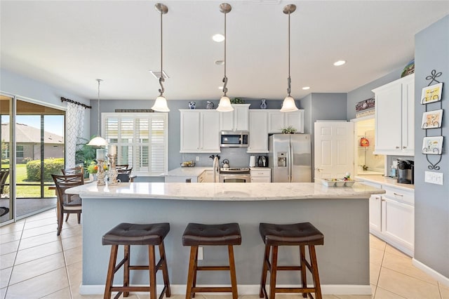 7333 SW 98th Ct, Ocala, FL 34481 - kitchen featuring appliances with stainless steel finishes, backsplash, a large island with sink, white cabinetry, and recessed lighting