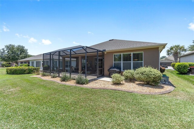 7333 SW 98th Ct, Ocala, FL 34481 - rear view of house featuring a lawn, glass enclosure, a patio, and stucco siding