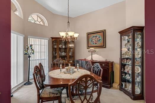 2434 Walnut Heights Rd, Apopka, FL 32703 - dining area featuring light carpet and a chandelier