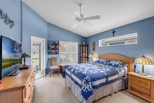 2434 Walnut Heights Rd, Apopka, FL 32703 - bedroom featuring vaulted ceiling, light carpet, access to exterior, and a ceiling fan