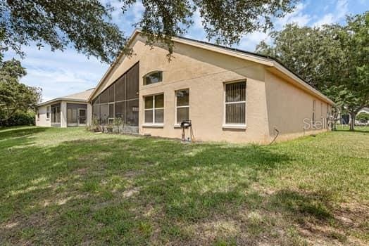 2434 Walnut Heights Rd, Apopka, FL 32703 - rear view of house with a lawn and stucco siding