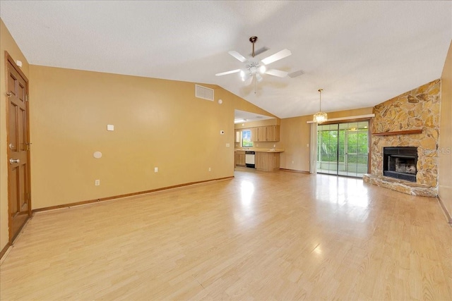 4331 SE 106th Pl, Belleview, FL 34420 - unfurnished living room featuring ceiling fan, vaulted ceiling, a stone fireplace, light wood finished floors, and baseboards