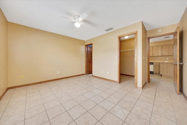 4331 SE 106th Pl, Belleview, FL 34420 - unfurnished bedroom with a spacious closet, a textured ceiling, a closet, baseboards, and a ceiling fan