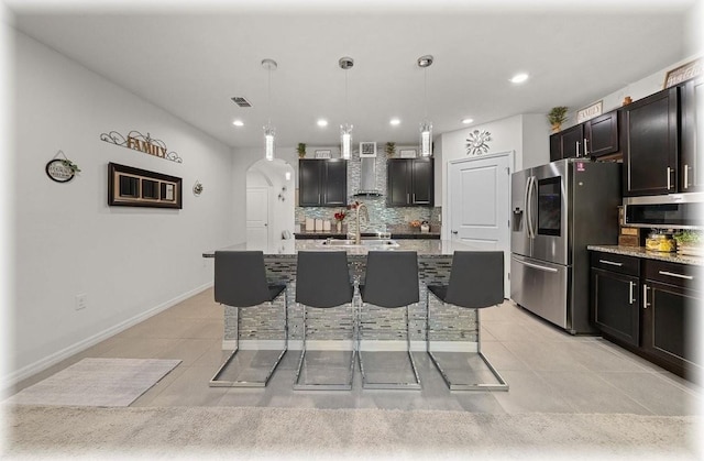 96 Hickory Crse, Ocala, FL 34472 - kitchen with appliances with stainless steel finishes, light tile patterned floors, backsplash, a breakfast bar area, and arched walkways