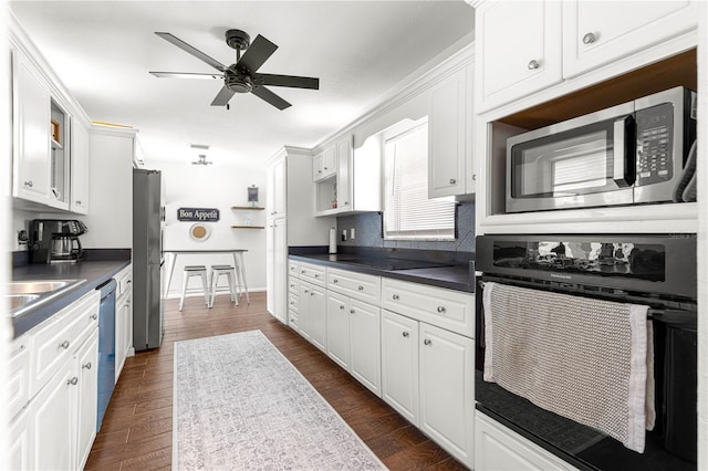 2475 SW 7th Ave, Ocala, FL 34471 - kitchen with black appliances, dark countertops, white cabinets, a ceiling fan, and dark wood-type flooring