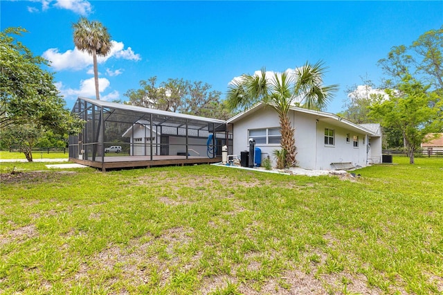 2475 SW 7th Ave, Ocala, FL 34471 - back of property featuring glass enclosure, stucco siding, a deck, and central AC unit