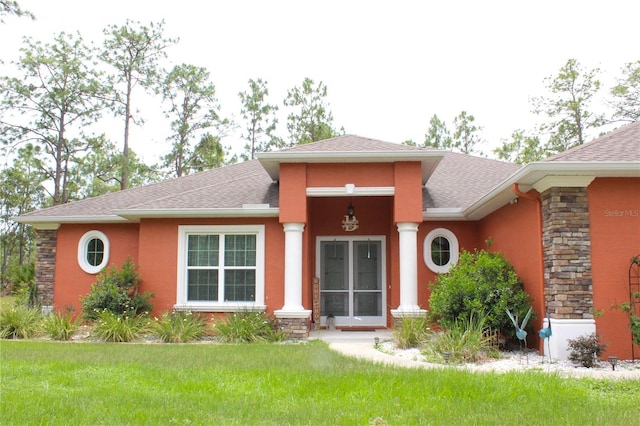 5306 W Comstock Pl, Beverly Hills, FL 34465 - view of front of property featuring stucco siding, a shingled roof, a front lawn, and stone siding