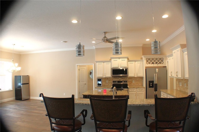 5306 W Comstock Pl, Beverly Hills, FL 34465 - kitchen featuring appliances with stainless steel finishes, ornamental molding, a ceiling fan, decorative backsplash, and a breakfast bar