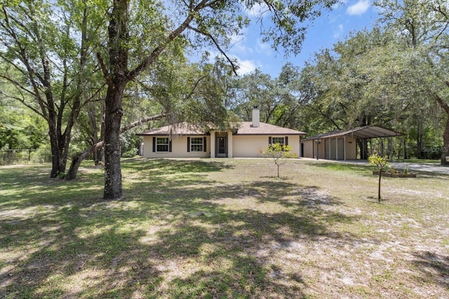 14131 SE 86th Ter, Inglis, FL 34449 - ranch-style home with a detached carport, a front yard, and a chimney
