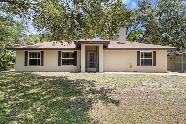 14131 SE 86th Ter, Inglis, FL 34449 - ranch-style home with a chimney, stucco siding, and a front yard