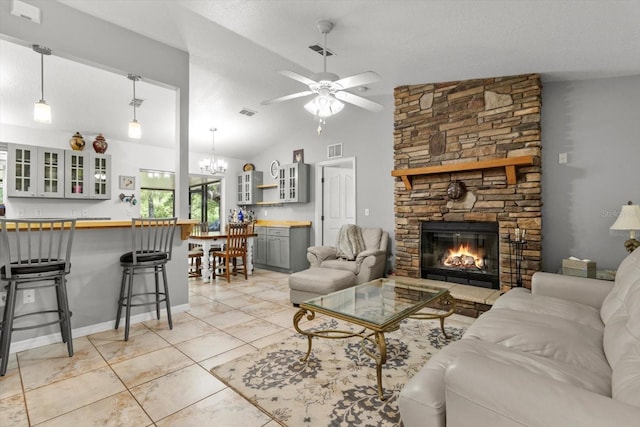 14131 SE 86th Ter, Inglis, FL 34449 - living room with a ceiling fan, a stone fireplace, vaulted ceiling, a chandelier, and light tile patterned floors
