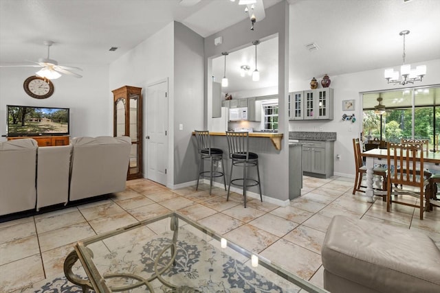 14131 SE 86th Ter, Inglis, FL 34449 - living area featuring a ceiling fan, a chandelier, baseboards, and light marble finish flooring
