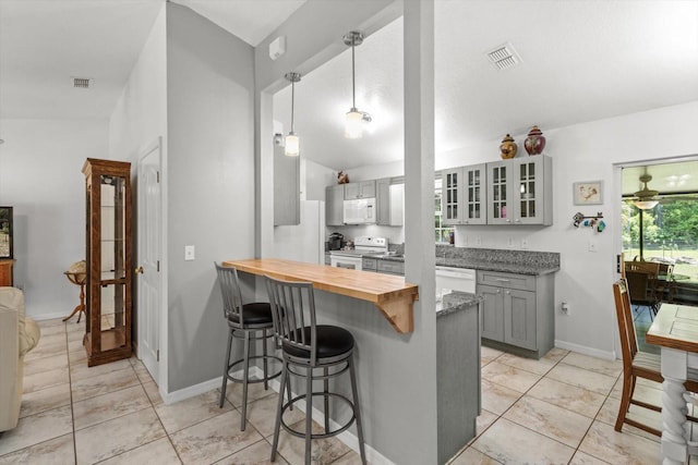 14131 SE 86th Ter, Inglis, FL 34449 - kitchen featuring white appliances, gray cabinets, a kitchen breakfast bar, glass insert cabinets, and a peninsula