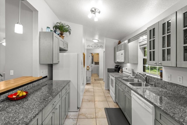 14131 SE 86th Ter, Inglis, FL 34449 - kitchen with white appliances, a sink, gray cabinetry, and dark stone counters