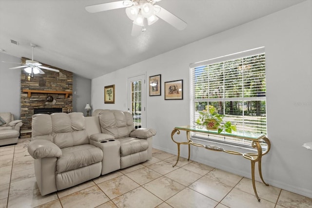 14131 SE 86th Ter, Inglis, FL 34449 - living room featuring ceiling fan, vaulted ceiling, a stone fireplace, and baseboards