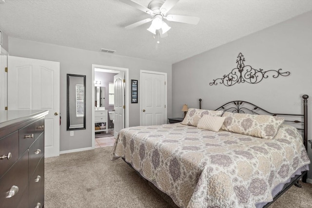 14131 SE 86th Ter, Inglis, FL 34449 - bedroom featuring light carpet, a textured ceiling, baseboards, ceiling fan, and connected bathroom