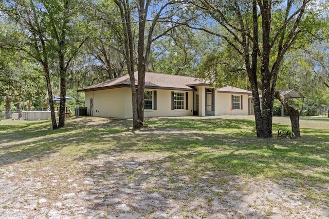 14131 SE 86th Ter, Inglis, FL 34449 - ranch-style home with central air condition unit, a front yard, and stucco siding