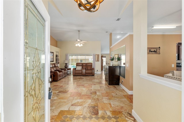 12495 SW 66th St, Ocala, FL 34481 - entryway featuring light stone finish flooring, a chandelier, baseboards, a ceiling fan, and crown molding