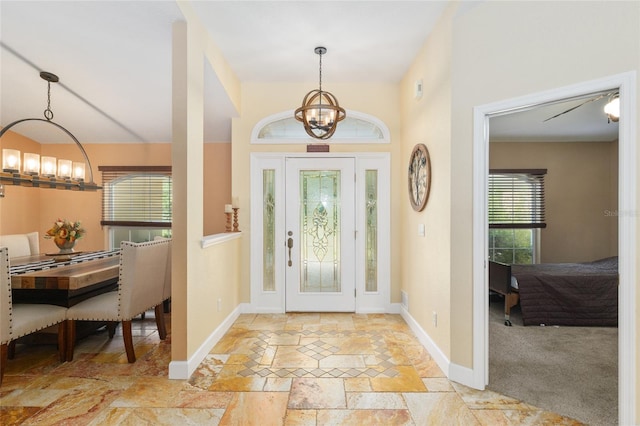 12495 SW 66th St, Ocala, FL 34481 - entrance foyer with a chandelier, stone tile flooring, and baseboards